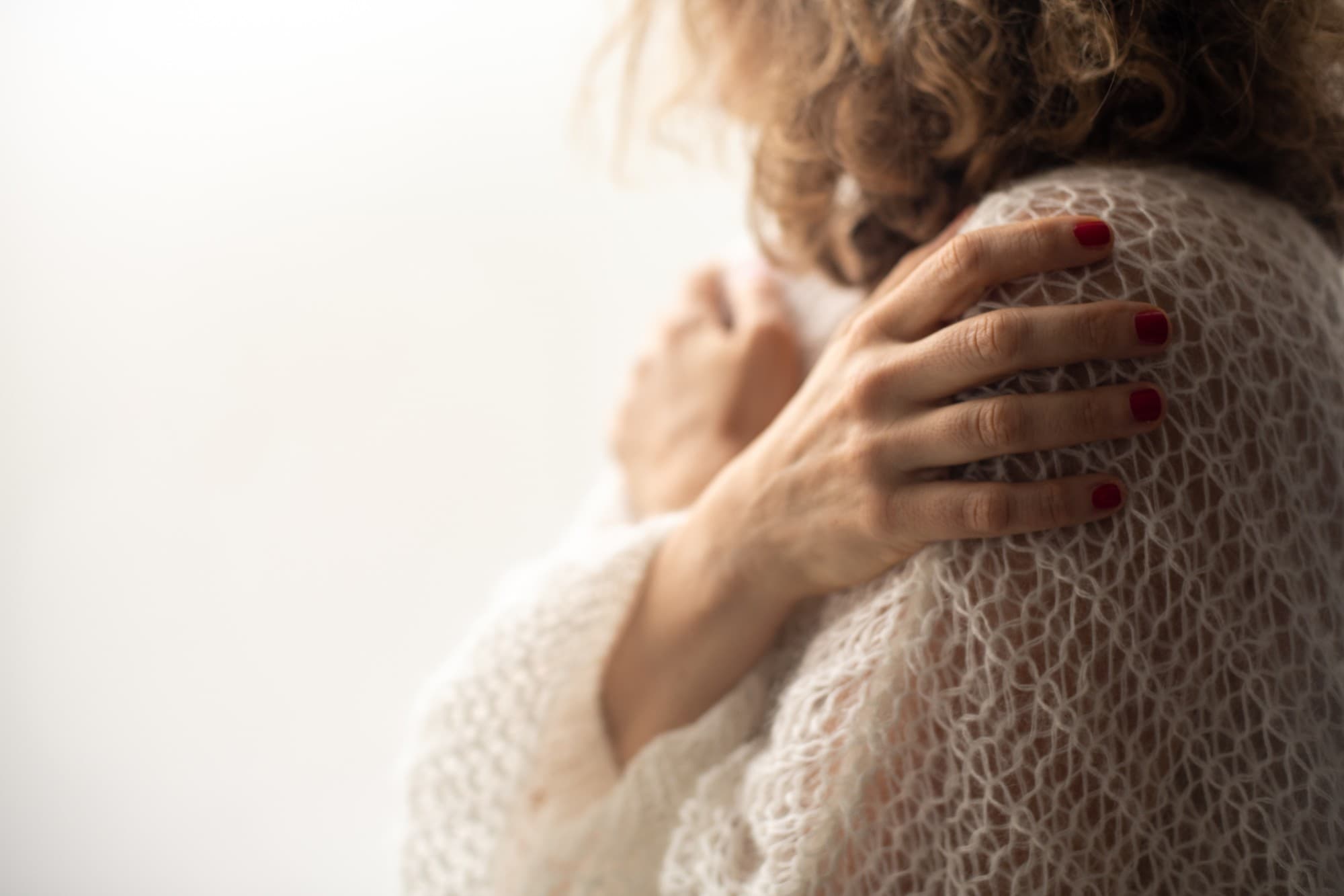 One woman's hand resting on another's shoulder