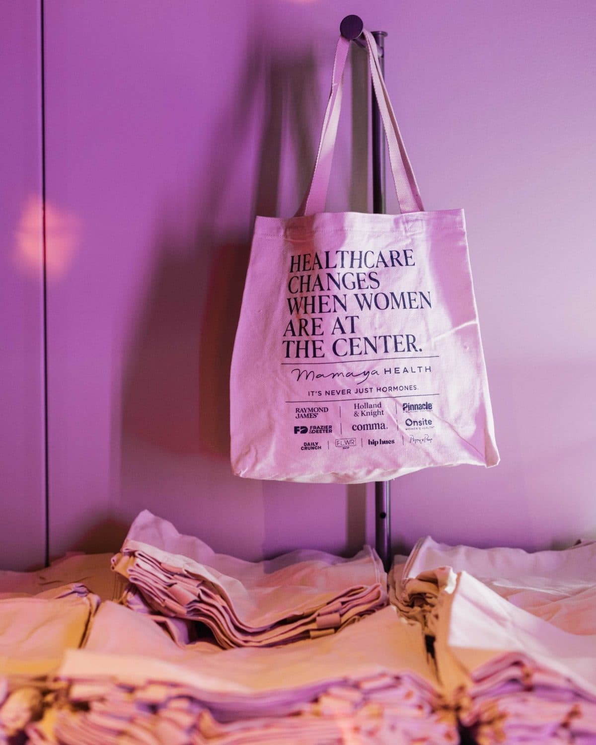A Mamaya Health tote bag reading “Healthcare changes when women are at the center.” at a Mamaya event