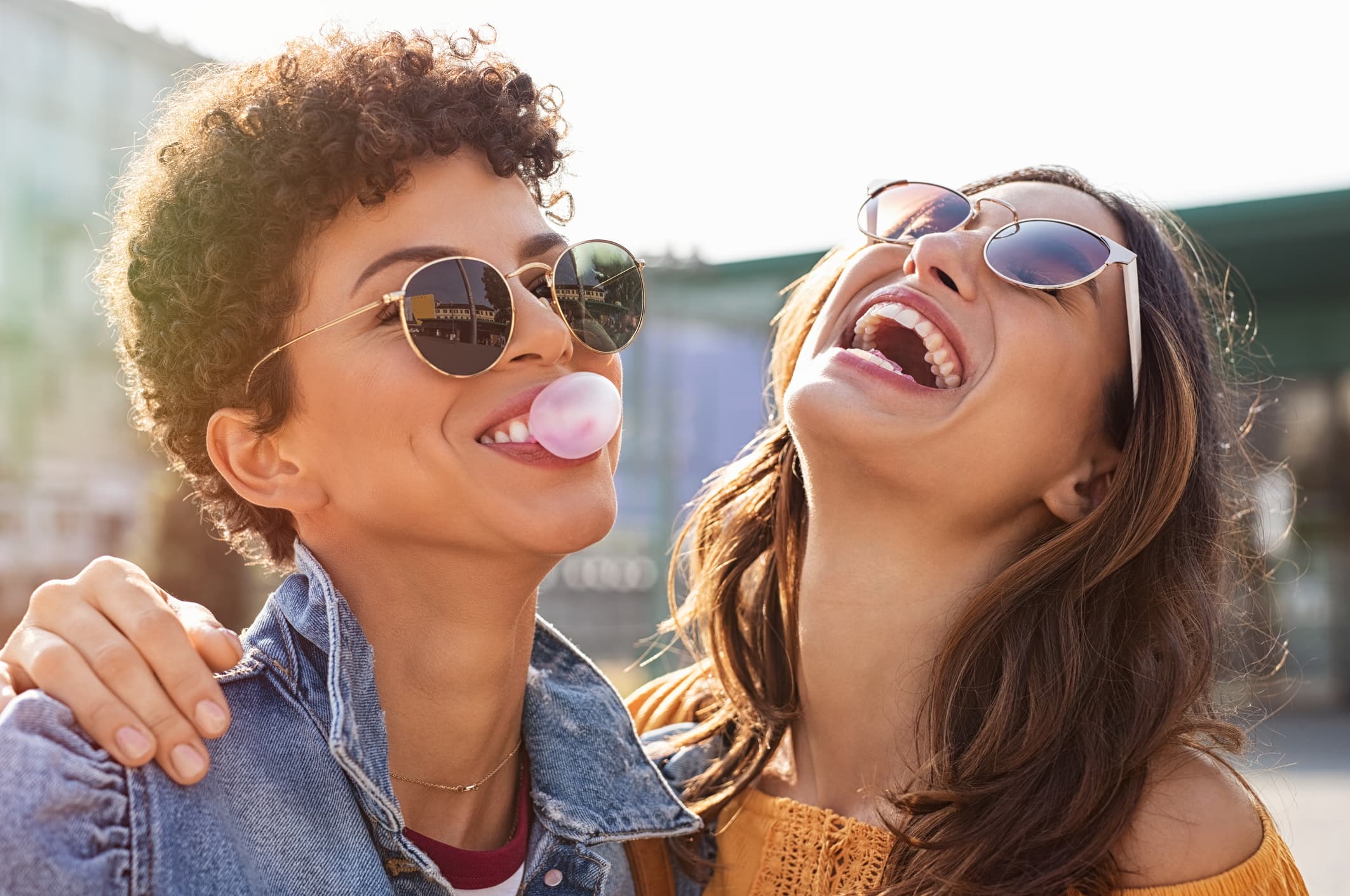 Two women laughing together in the sunshine